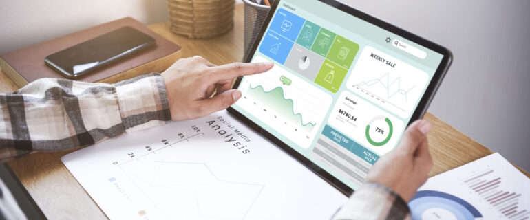 Businesswoman using a tablet to analysis graph company finance strategy statistics success concept and planning for future in office room.